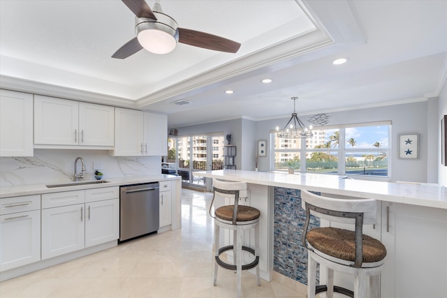 kitchen with dishwasher, white cabinetry, ornamental molding, a breakfast bar area, and sink