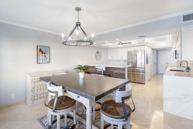 dining area featuring sink, an inviting chandelier, and crown molding