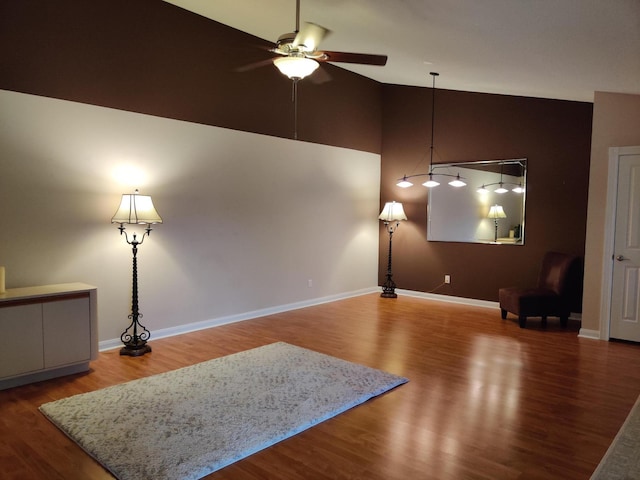 living room with hardwood / wood-style flooring, ceiling fan, and high vaulted ceiling