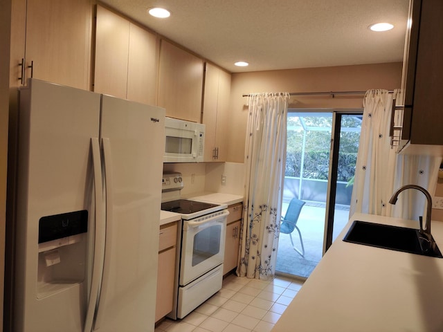 kitchen with light tile patterned flooring, white appliances, sink, and a textured ceiling