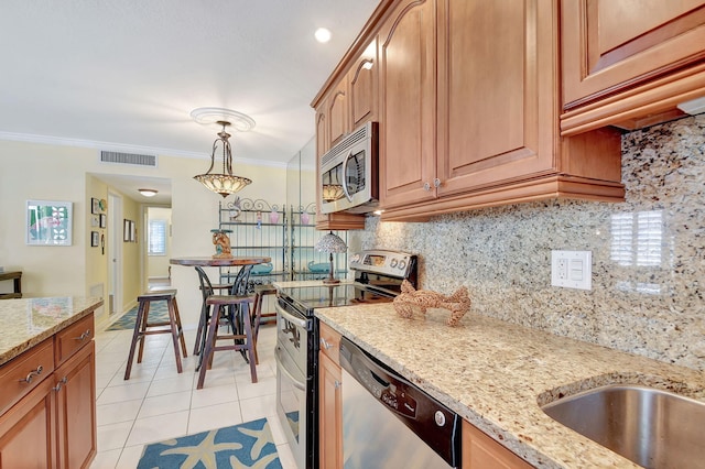 kitchen featuring light stone countertops, ornamental molding, stainless steel appliances, and tasteful backsplash