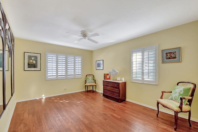 sitting room featuring ceiling fan, a wealth of natural light, and light wood-type flooring