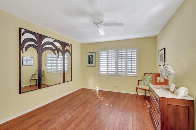 sitting room with ceiling fan and light wood-type flooring