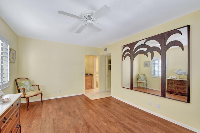 living area with ceiling fan and light hardwood / wood-style flooring