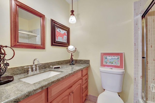 bathroom with toilet, an enclosed shower, and vanity