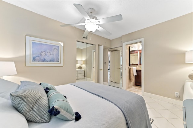 bedroom featuring ceiling fan, light tile patterned floors, ensuite bath, and a closet