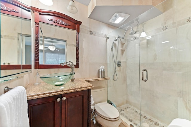 bathroom featuring vanity, a shower with door, and toilet