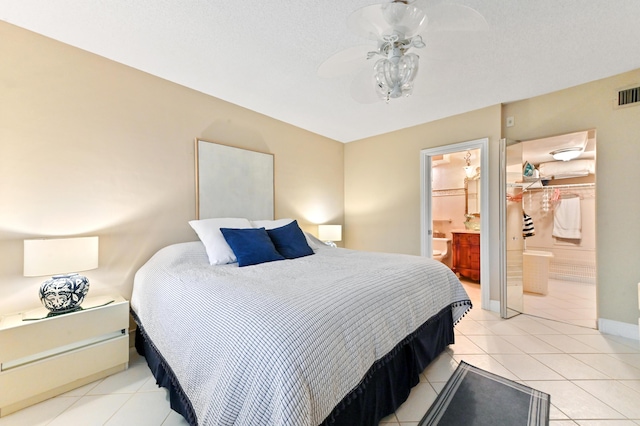 tiled bedroom with ceiling fan and ensuite bath