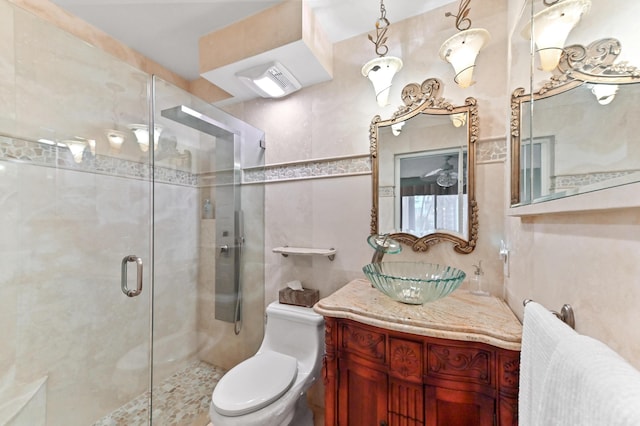 bathroom featuring vanity, toilet, an enclosed shower, and tile walls