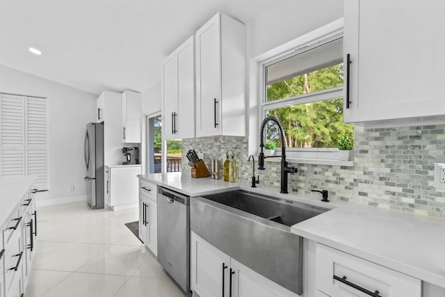 kitchen featuring sink, light tile patterned floors, tasteful backsplash, white cabinetry, and stainless steel appliances