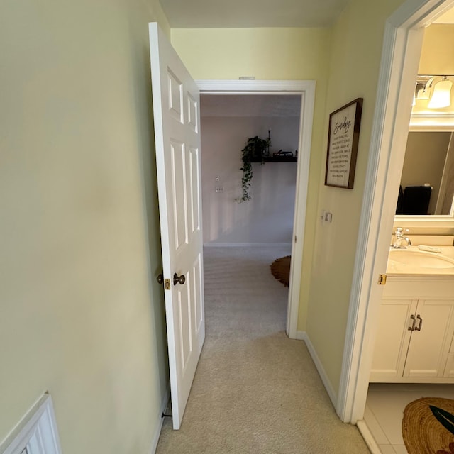 hallway featuring sink and light carpet