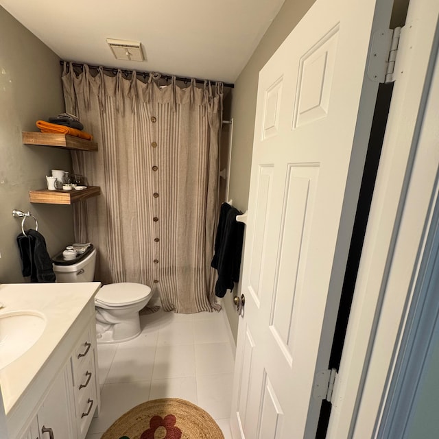 bathroom with toilet, tile patterned floors, and vanity