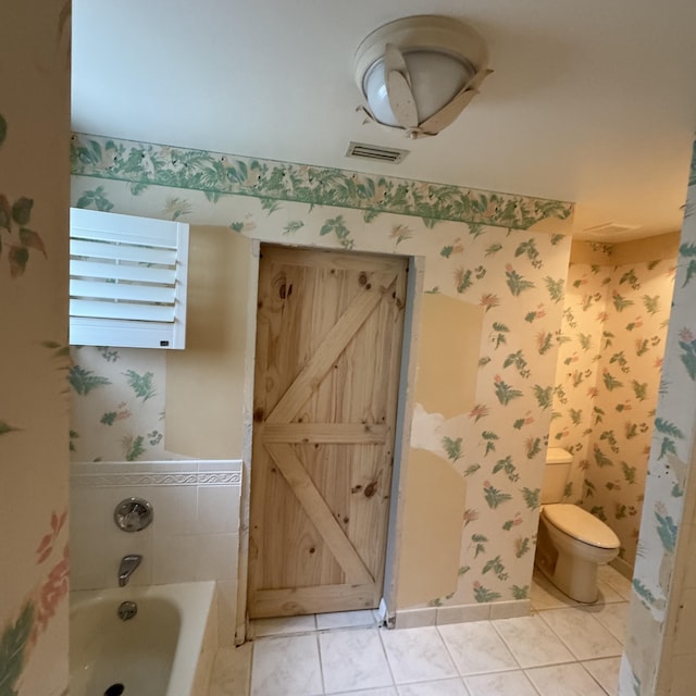 bathroom featuring a tub to relax in, tile patterned floors, and toilet