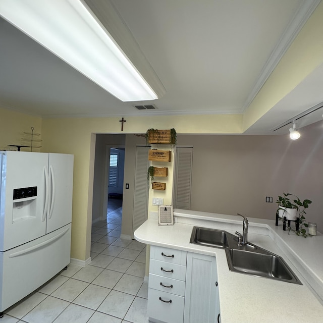 kitchen with white refrigerator with ice dispenser, crown molding, white cabinets, light tile patterned flooring, and sink