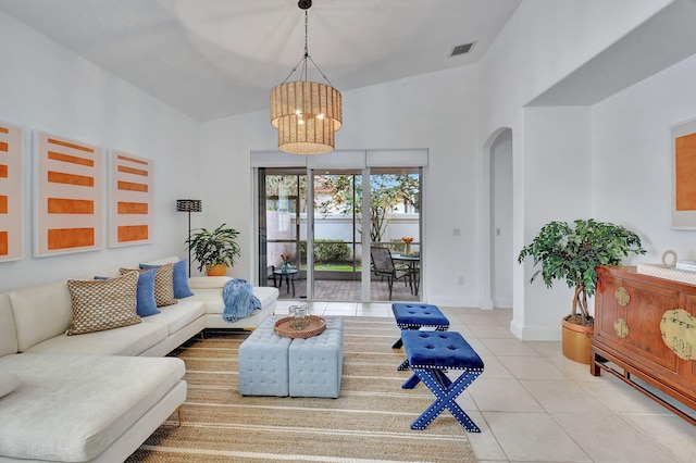 tiled living room with an inviting chandelier and a high ceiling