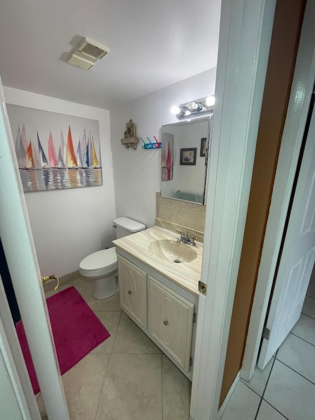 bathroom featuring tile patterned flooring, vanity, and toilet