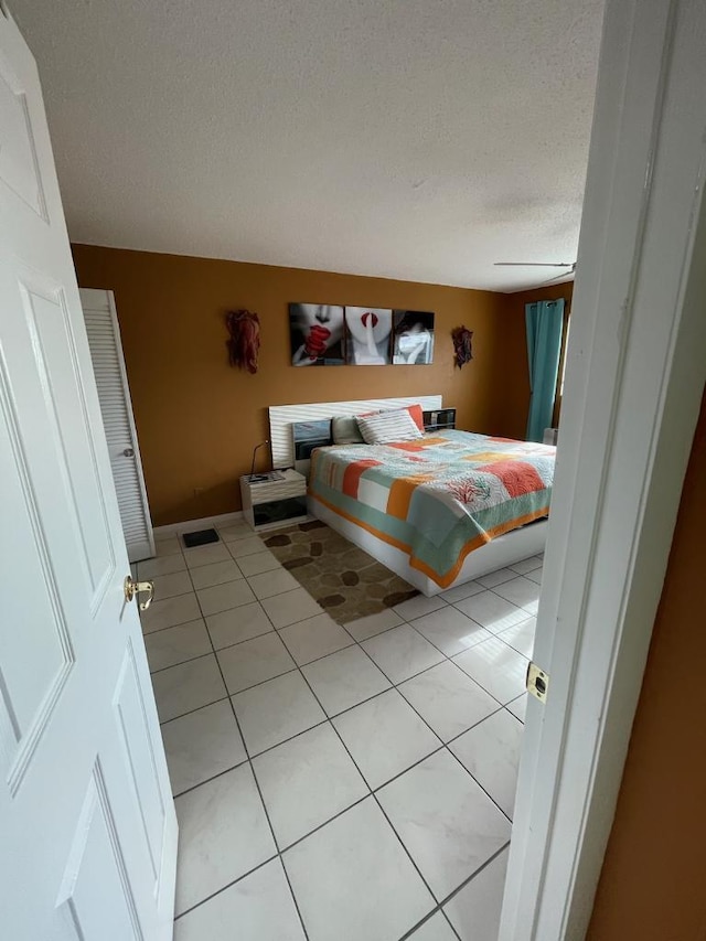 bedroom with a textured ceiling and light tile patterned flooring