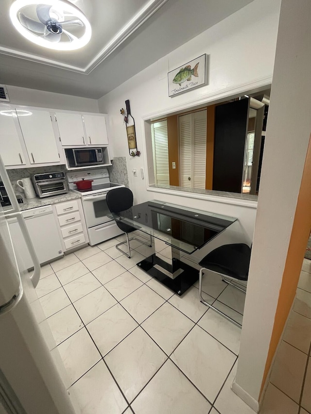 kitchen with light tile patterned floors, white cabinets, and white appliances