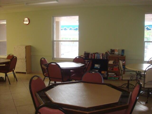 dining space featuring crown molding, a healthy amount of sunlight, and light tile patterned flooring