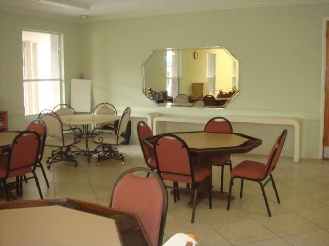 dining space featuring light tile patterned floors and ornamental molding