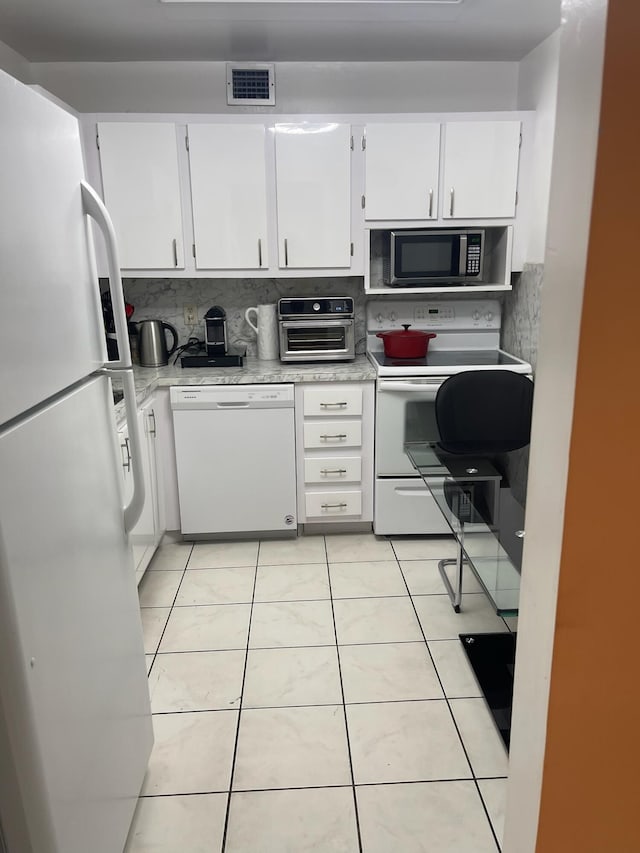 kitchen featuring white cabinets, decorative backsplash, white appliances, and light tile patterned floors