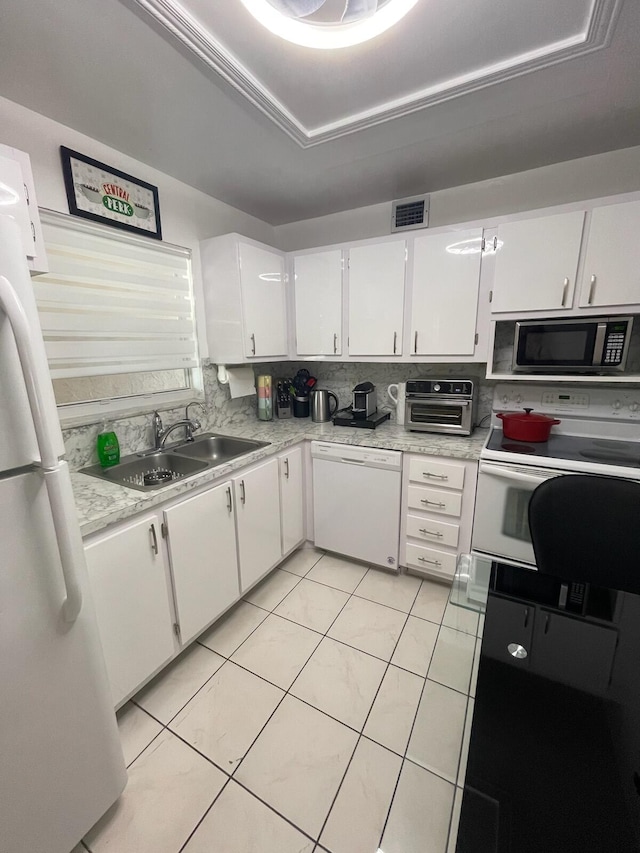 kitchen with white cabinets, white appliances, sink, and light tile patterned floors