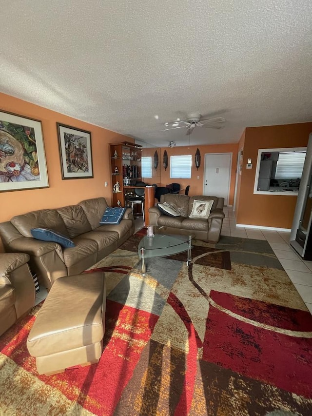 tiled living room featuring ceiling fan and a textured ceiling