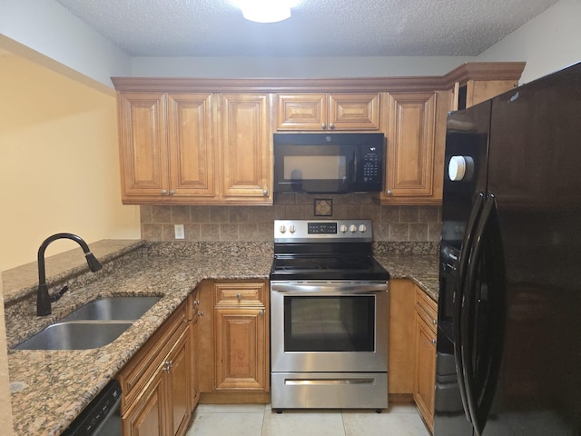 kitchen with stone countertops, sink, tasteful backsplash, and black appliances