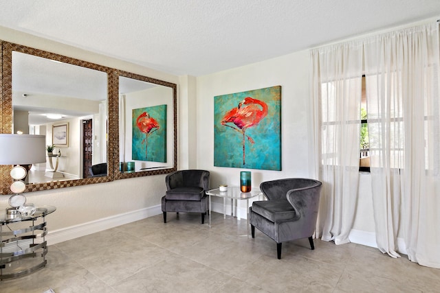 living area featuring a textured ceiling and light tile patterned flooring