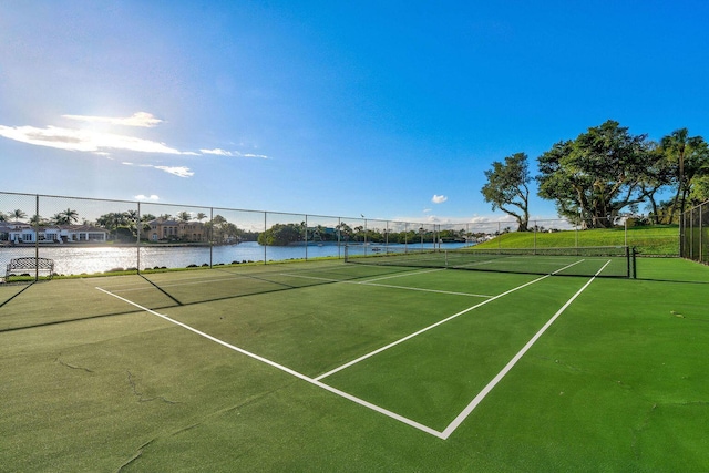 view of tennis court with a water view