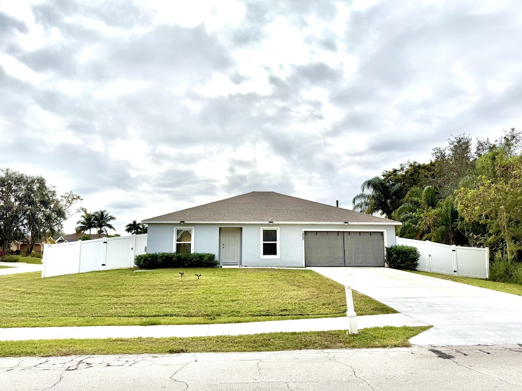 single story home with a front yard and a garage