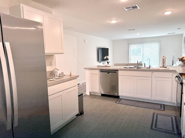 kitchen with sink, stainless steel appliances, kitchen peninsula, and white cabinetry