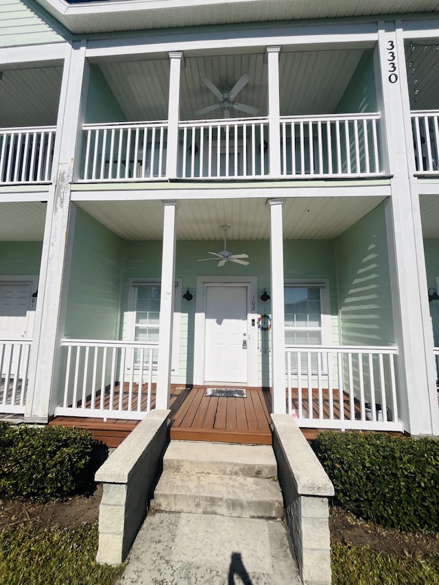 entrance to property with ceiling fan, a porch, and a balcony