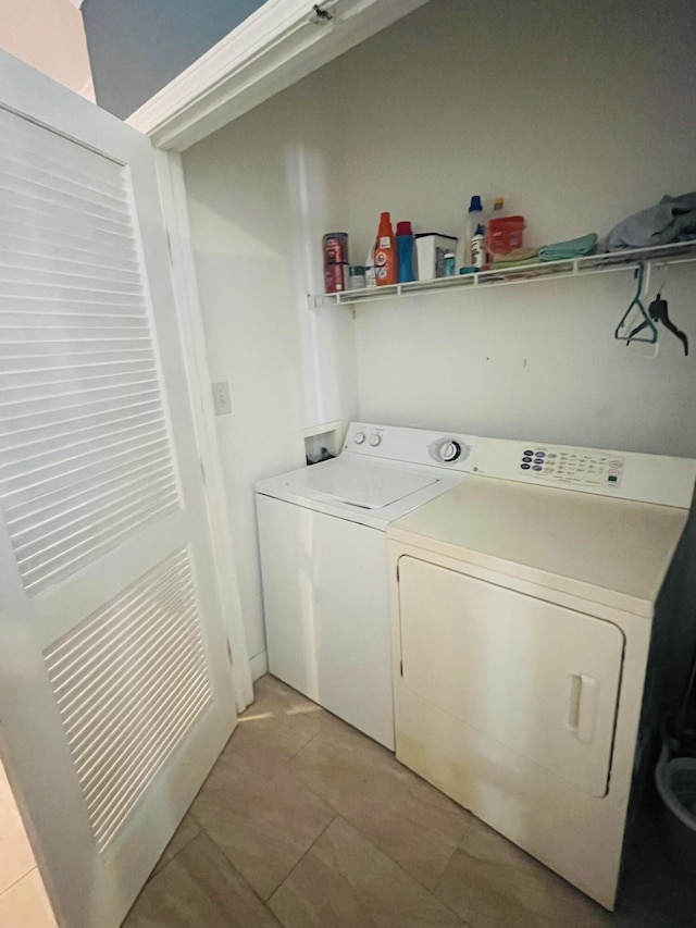 laundry room featuring washing machine and dryer and light tile patterned floors