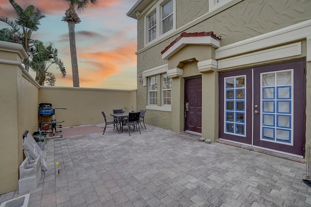 patio terrace at dusk featuring french doors