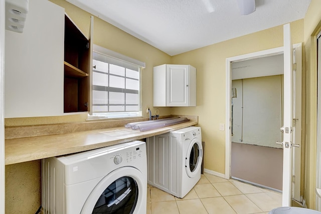 laundry area with sink, light tile patterned floors, and washing machine and dryer