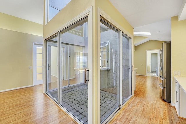 entryway with lofted ceiling and light hardwood / wood-style floors