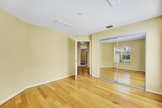 unfurnished bedroom featuring hardwood / wood-style floors and a closet