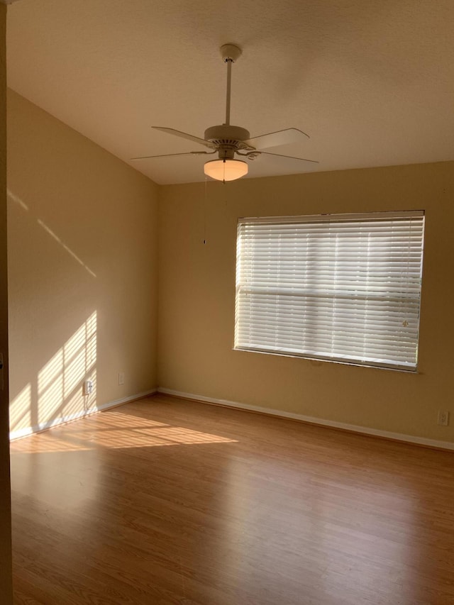 spare room with ceiling fan and light wood-type flooring