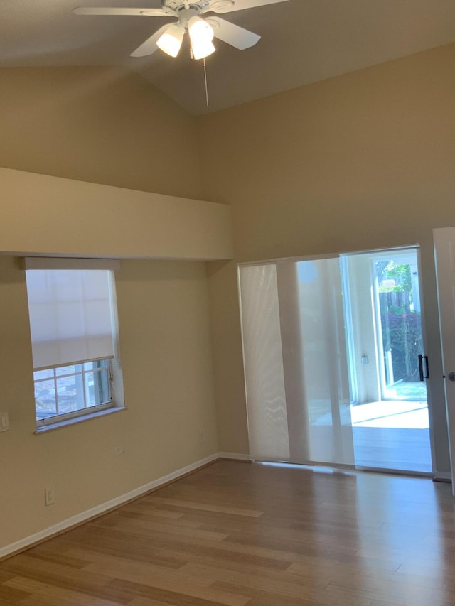 unfurnished room with wood-type flooring, plenty of natural light, high vaulted ceiling, and ceiling fan