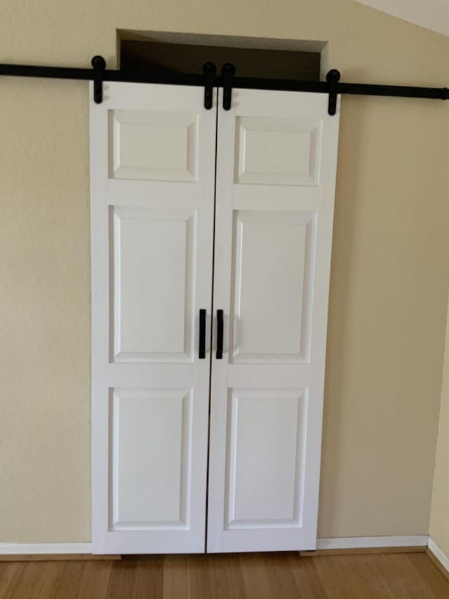 room details with hardwood / wood-style flooring and a barn door