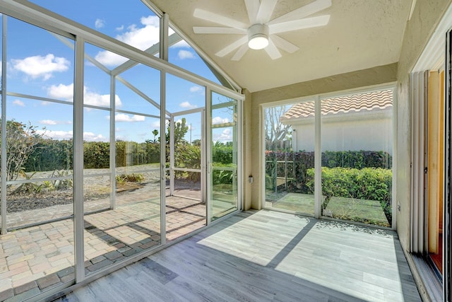 unfurnished sunroom with lofted ceiling and ceiling fan