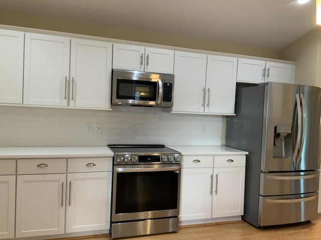 kitchen featuring appliances with stainless steel finishes, decorative backsplash, and white cabinets