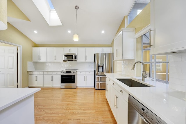 kitchen featuring pendant lighting, white cabinetry, stainless steel appliances, and sink