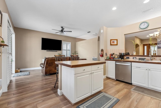 kitchen featuring stainless steel dishwasher, white cabinetry, sink, and tasteful backsplash