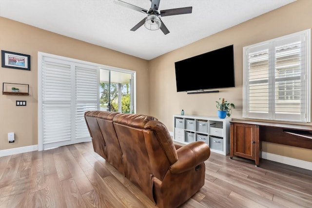 living room with ceiling fan and light hardwood / wood-style flooring