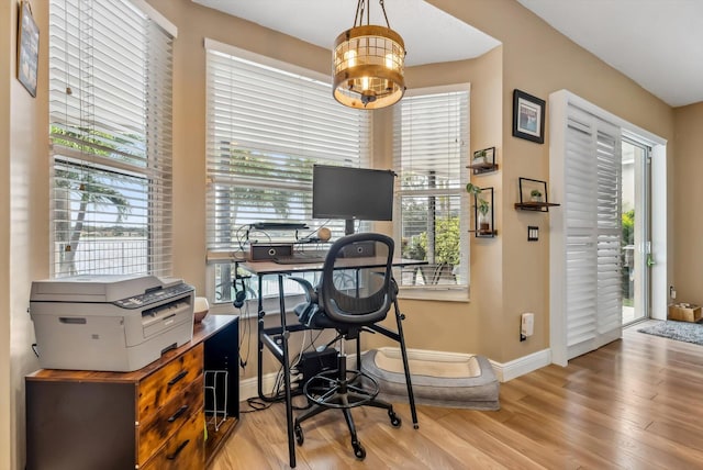 office space featuring light hardwood / wood-style floors, a notable chandelier, and plenty of natural light