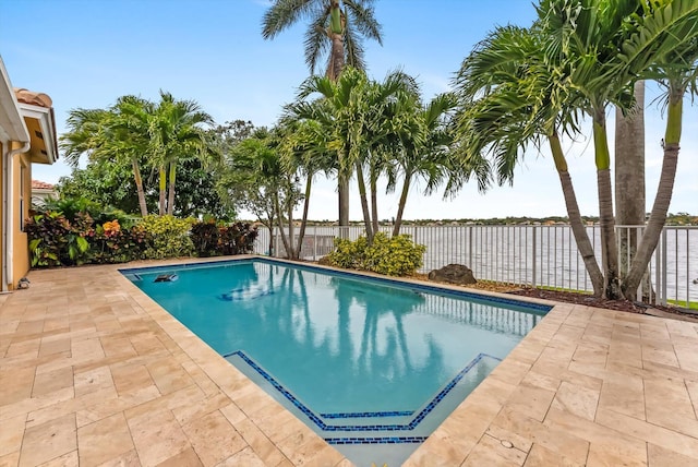 view of swimming pool featuring a water view and a patio area