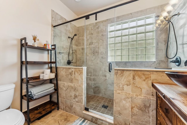 bathroom with tile patterned flooring, an enclosed shower, vanity, and toilet