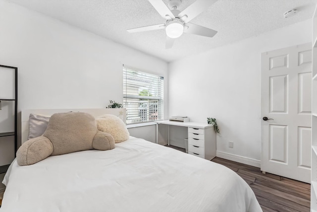 bedroom featuring a textured ceiling, ceiling fan, and dark hardwood / wood-style floors